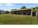 Large, covered metal storage building in a spacious backyard with a wood fence and well-maintained lawn at 45 Hawley Ridge Dr, Dunn, NC 28334