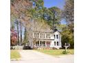 Classic two-story home with a welcoming front porch, set amongst mature trees in a tranquil neighborhood at 5013 Brassfield Dr, Rocky Mount, NC 27803