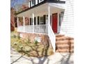 Inviting front porch featuring brick accents, a vibrant red door, and fresh landscaping, for a welcoming entrance at 5013 Brassfield Dr, Rocky Mount, NC 27803