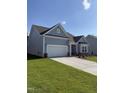 Light blue single-story home with attached two-car garage and green lawn and garden at 529 Winding Creek Drive Dr, Lillington, NC 27546