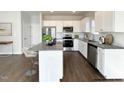 Bright kitchen featuring white cabinets, stainless steel appliances, and a granite countertop island at 58 Butterbean Ct, Zebulon, NC 27597