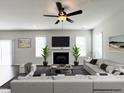 Inviting living room with a ceiling fan, fireplace, and comfortable seating at 58 Butterbean Ct, Zebulon, NC 27597
