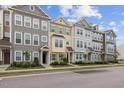 Charming townhomes with varied color palettes, tidy lawns, and welcoming front entrances on a sunny day at 608 Grand Central Sta, Apex, NC 27502