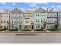 Daytime street view showcases well-maintained townhouses with uniform landscaping and dedicated parking spaces at 608 Grand Central Sta, Apex, NC 27502