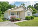 Charming one-story home with light-yellow siding, blue shutters, a cozy porch, and lovely landscaping at 6904 Fox Haven Pl, Raleigh, NC 27616