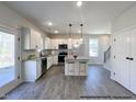 Bright kitchen featuring white cabinets, stainless steel appliances, and an island at 79 Butterbean Ct, Zebulon, NC 27597