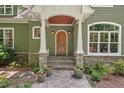 Charming entrance features a stone pathway, wood door, stone accents, and a covered porch at 8232 Glynmorgan Way, Chapel Hill, NC 27516