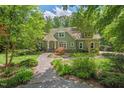 Charming two-story home featuring a stone walkway and beautifully landscaped front yard surrounded by mature trees at 8232 Glynmorgan Way, Chapel Hill, NC 27516