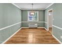 Light-filled dining room with hardwood floors, complemented by light green walls and white trim at 917 Saint Marys St, Raleigh, NC 27605