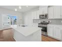 New kitchen features stainless appliances, white cabinets, and island at 919 Montague Ave, Durham, NC 27703