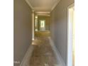 Hallway featuring elegant crown molding leading to a bright entryway and open floor plan at 9254 Turkey Way, Middlesex, NC 27557
