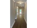 Inviting hallway featuring sleek hardwood floors and neutral-toned walls, leading to rooms bathed in natural light at 9254 Turkey Way, Middlesex, NC 27557