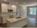 Modern kitchen with white cabinets, granite countertops, stainless steel appliances, and stylish pendant lighting at 9254 Turkey Way, Middlesex, NC 27557