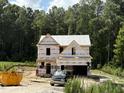 New two-story home under construction featuring a two-car garage and a wooded lot at 93 Butterbean Ct, Zebulon, NC 27597