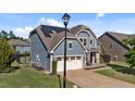 Two-story home with solar panels, two-car garage and a cozy front patio with chairs at 94 Pearsall Farm Ln, Clayton, NC 27527