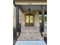 Inviting front porch with brickwork, a hanging lantern, and wood columns at 976 Knob Hill Dr., Hillsborough, NC 27278