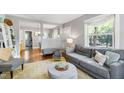 Comfortable living room featuring hardwood floors, a plush gray sofa, and abundant natural light at 1003 E Club Blvd, Durham, NC 27704