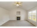 Living room with a fireplace, large window, and neutral walls perfect for entertaining at 1003 Walnut Dr, Erwin, NC 28339