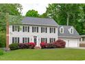 Charming two-story home with a well-manicured lawn, beautiful flowers, and a two-car garage at 1007 Wellstone Cir, Apex, NC 27502