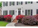 Inviting front entrance with brick steps and vibrant red rose bushes enhancing curb appeal at 1007 Wellstone Cir, Apex, NC 27502