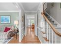 Elegant hallway with hardwood floors, staircase, and open view to the dining room at 1007 Wellstone Cir, Apex, NC 27502