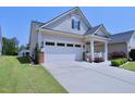 Home's exterior featuring a two-car garage and a meticulously maintained lawn at 1033 Cuthbert Ln, Durham, NC 27703