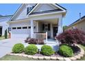 Home's charming covered porch featuring neatly landscaped shrubbery at 1033 Cuthbert Ln, Durham, NC 27703