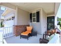 Cozy porch seating area with wicker chairs, an orange chaise lounge, and decor at 1033 Cuthbert Ln, Durham, NC 27703
