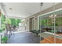 Relaxing covered deck with comfortable seating and wooded views, perfect for outdoor dining at 108 Christy Circle Ln, Clayton, NC 27520