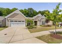 Charming one-story home boasts a well-kept lawn, landscaped garden beds, and an attached two-car garage at 1129 Santa Cruz St, Wake Forest, NC 27587