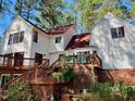 A grand home's back exterior showcasing wood lattice under the deck and an inviting staircase at 11813 Edgewater Ct, Raleigh, NC 27614