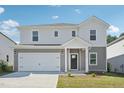 An exterior shot showcases a charming two-story home with attached two car garage and manicured front lawn at 1730 Pie Filling Dr, Haw River, NC 27258