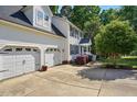 Side view of a two-story home with a three car garage and green lawn at 215 Rocky Point Ct, Fuquay Varina, NC 27526