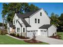 Stylish new construction home showing the three-car garage and attractive backyard landscaping at 219 George Hudson Rd, Siler City, NC 27344