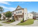 Attractive townhome exterior features a brick front, attached garage, and manicured lawn on a sunny day at 2211 Sweet Annie Way, Wake Forest, NC 27587
