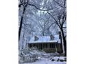 Charming home covered in snow with a cozy front porch and mature trees at 2603 Red Pine Rd, Hillsborough, NC 27278