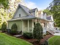 Well-maintained home exterior featuring a covered porch, lush landscaping, and manicured lawn at 2616 Dockery Ln, Raleigh, NC 27606