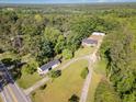 An aerial view of a wooded property featuring multiple structures and a winding driveway at 2670 Nc 210 S, Lillington, NC 27546