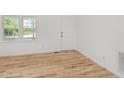 Bright entryway with new wood flooring, a white door, and a double window at 2670 Nc 210 S, Lillington, NC 27546