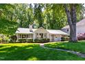 View of a white house with manicured lawn and mature trees at 3028 Rothgeb Dr, Raleigh, NC 27609