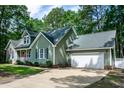 Side view of this lovely home featuring an attached garage and a well-maintained lawn and landscaping at 305 Monterey Ct, Benson, NC 27504