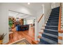 Open-concept living room with hardwood floors, a fireplace, and a staircase at 3201 Keighley Forest Dr, Wake Forest, NC 27587