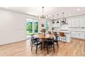 Bright, open kitchen with white cabinets, granite countertops, stainless steel appliances, and a stylish dining area at 325 Porterfield Dr, Youngsville, NC 27596