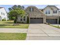 Charming home with a brick facade, two-car garage, and professionally landscaped front yard at 3406 Antler View Dr, Apex, NC 27502