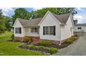 Well-maintained exterior view showcasing a white home with black shutters and a spacious gravel driveway at 3603 Westmeadow Ln, Elon, NC 27244