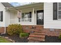 Cozy front porch with brick steps and a decorative welcome sign, perfect for relaxing outdoors at 3603 Westmeadow Ln, Elon, NC 27244