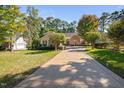 Charming single-story home featuring stone accents, a well-manicured lawn, and a long driveway at 39 Forked Pine Ct, Chapel Hill, NC 27517