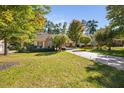 Charming single-story home featuring stone accents, a well-manicured lawn, and a long driveway at 39 Forked Pine Ct, Chapel Hill, NC 27517