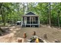 Charming front exterior of cabin with cozy porch, inviting fire pit, and natural surroundings at 4022 Tecolote Way, Hillsborough, NC 27278