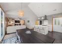 Open-concept kitchen with island seating, modern lighting, and a seamless flow to the dining and living areas at 4022 Tecolote Way, Hillsborough, NC 27278